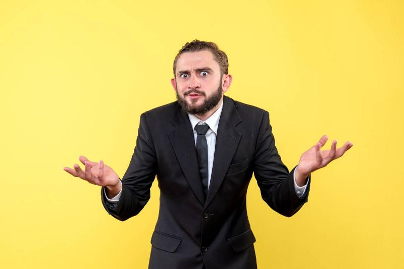 man in suit shrugging shoulders