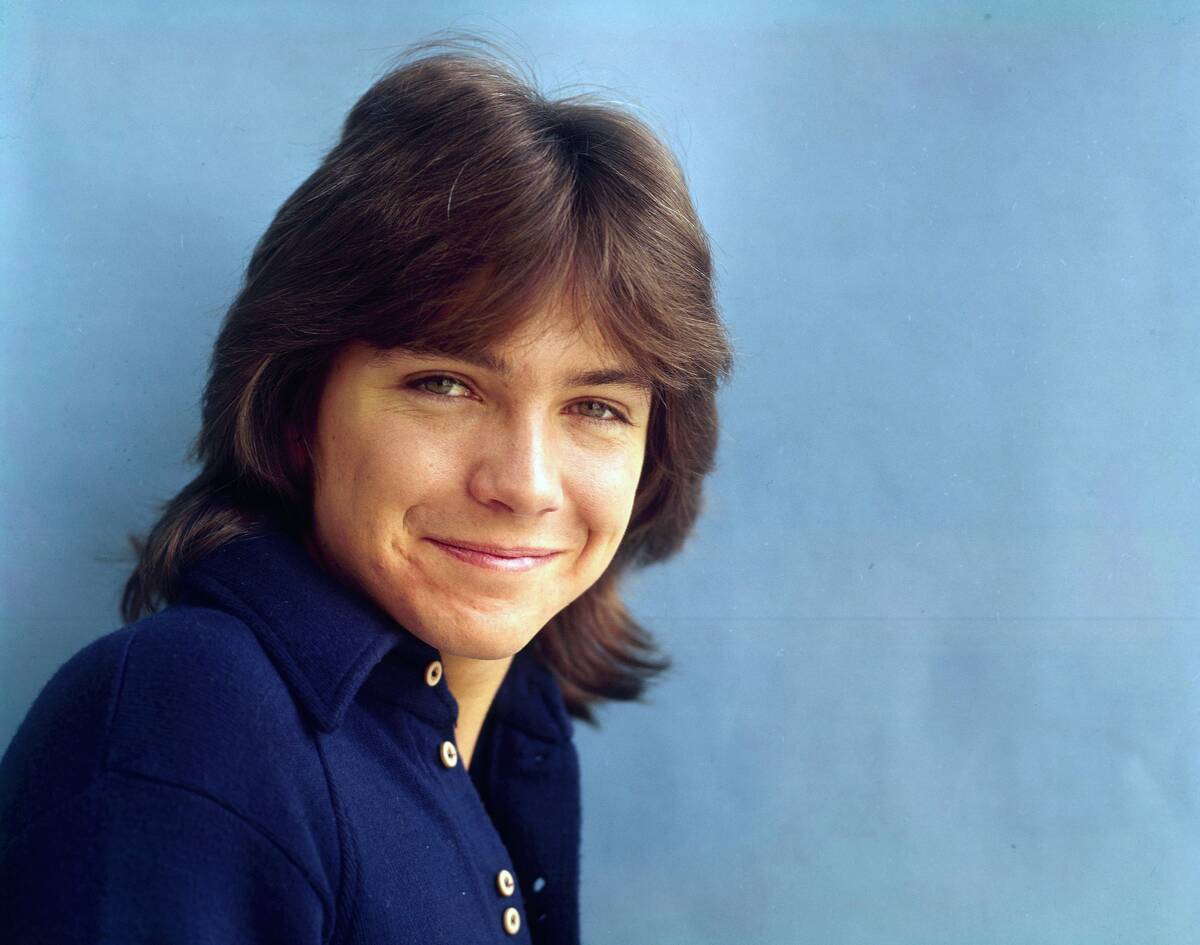 teen boy in front of a blue background