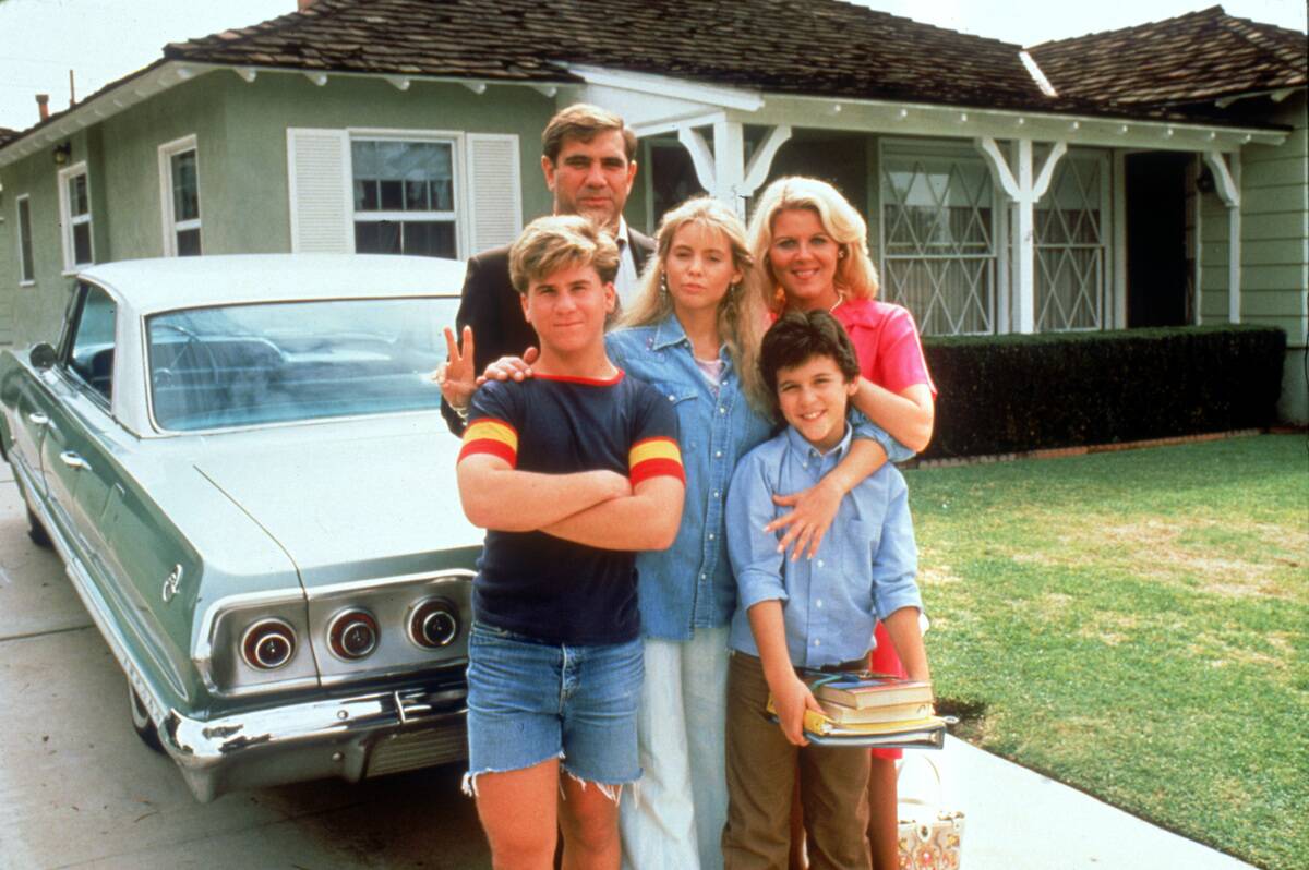 family in front of house next to a car