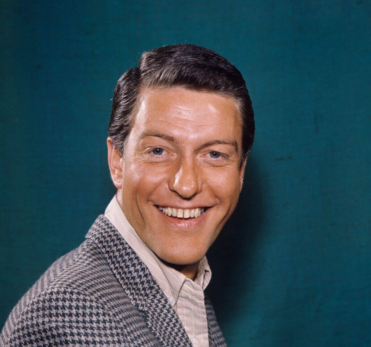 man in front of a teal background