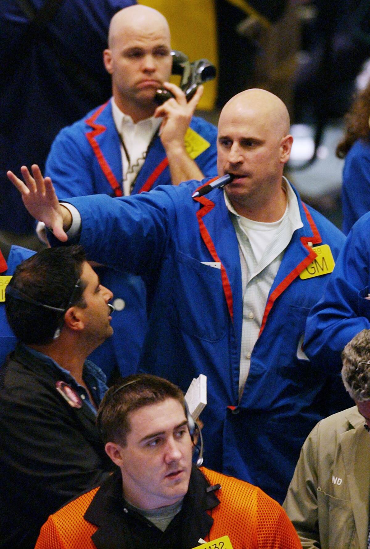 A crude oil futures traders chews on a ballpoint pen as he w