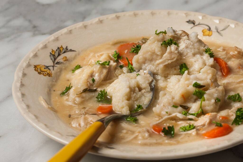 chicken and dumplings in a stew with carrots and parsley