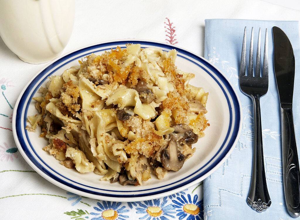 Curly pasta and mushrooms add to this tuna casserole along with a topping of grated cheddar and bread crumbs