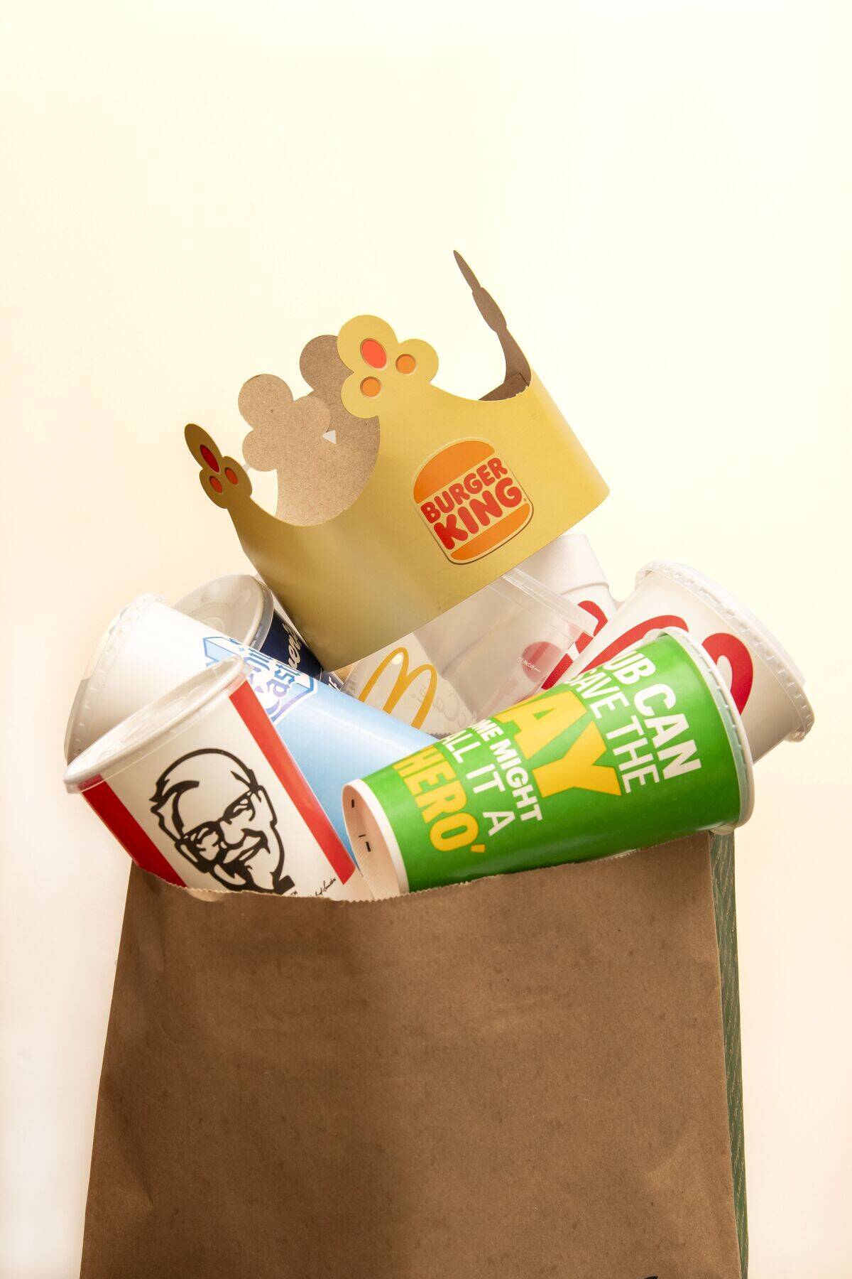 A trash bag full of fast food drink containers from a variety of fast food restaurants