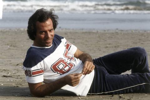 Julio Iglesias posing lying on the seashore