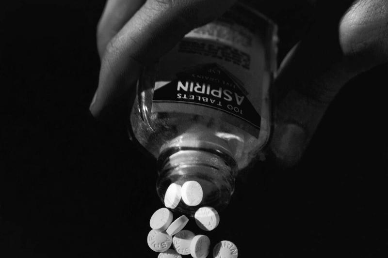 Hand Pouring Aspirin from Bottle