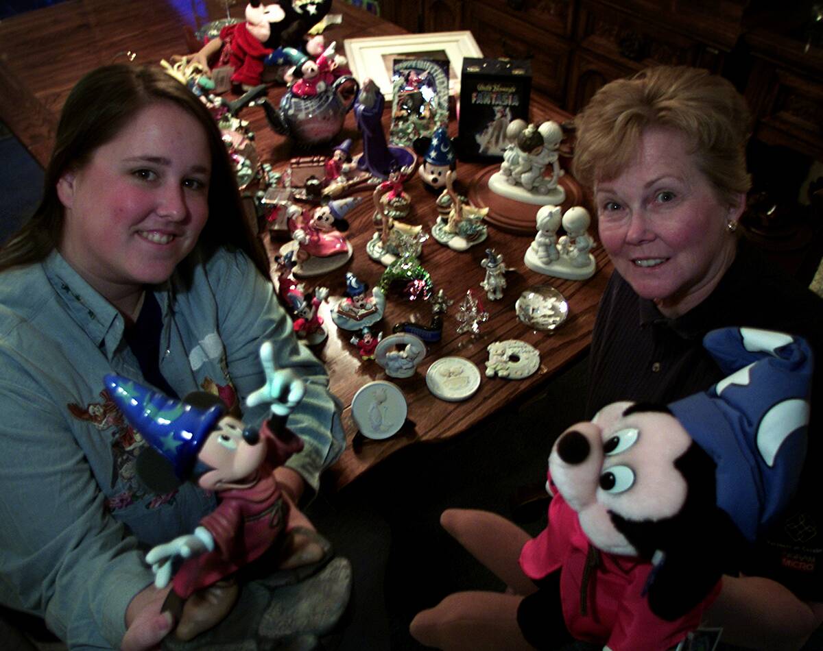 Tess, left, and mother, Donna Ferrari, of Tustin, show off some of their Disney's The Sorcer's Appre
