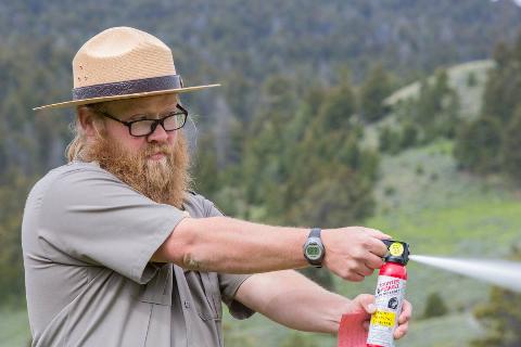 Man demonstrating how to use bear spray. 