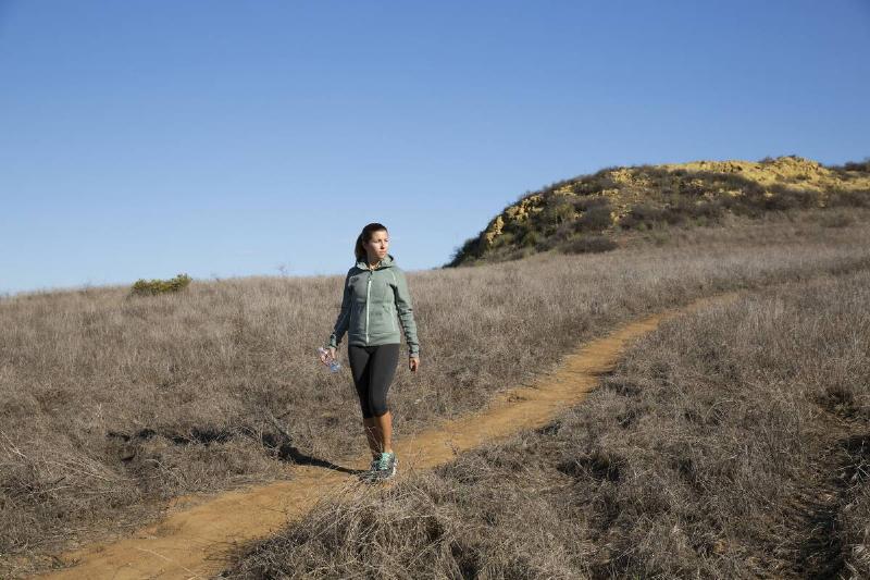 Female runner moving down a hill path