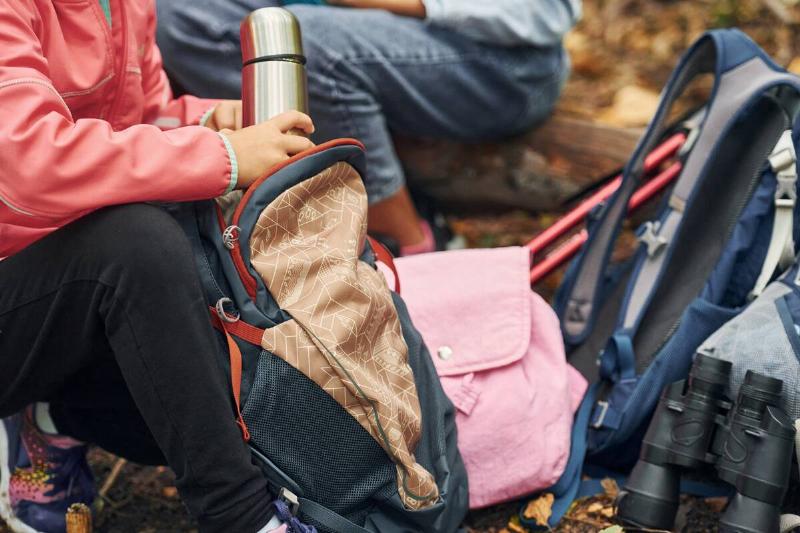 Person packing a thermos in a bag. 
