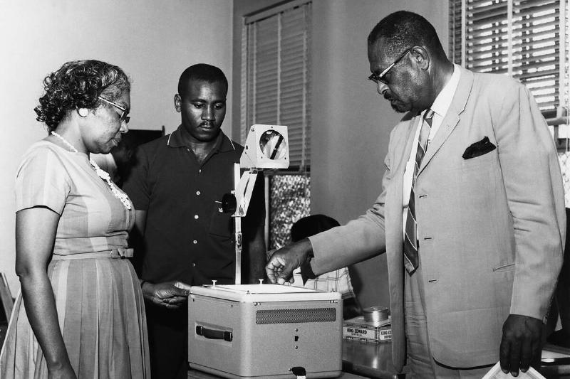 Faculty members checking machine in college