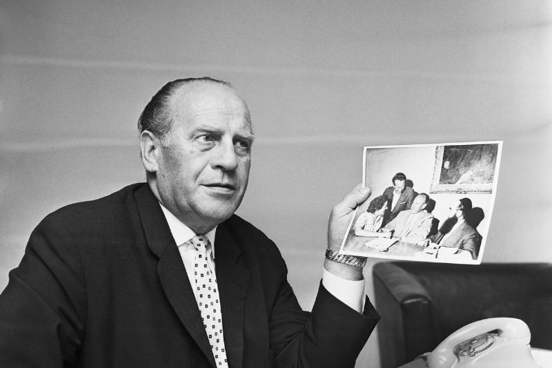 Oskar Schindler Hold Photos of Holocaust