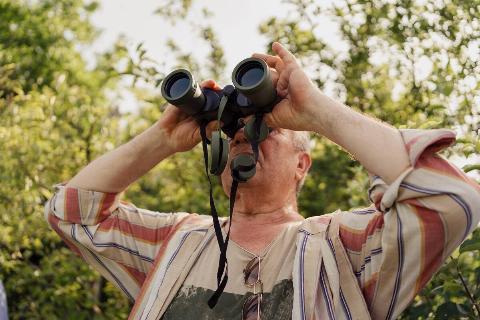 Man looking through binoculars. 