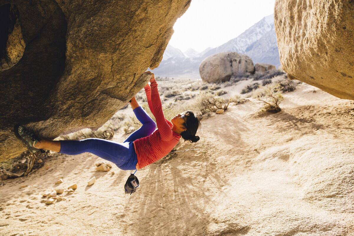 a woman free soloing a boulder