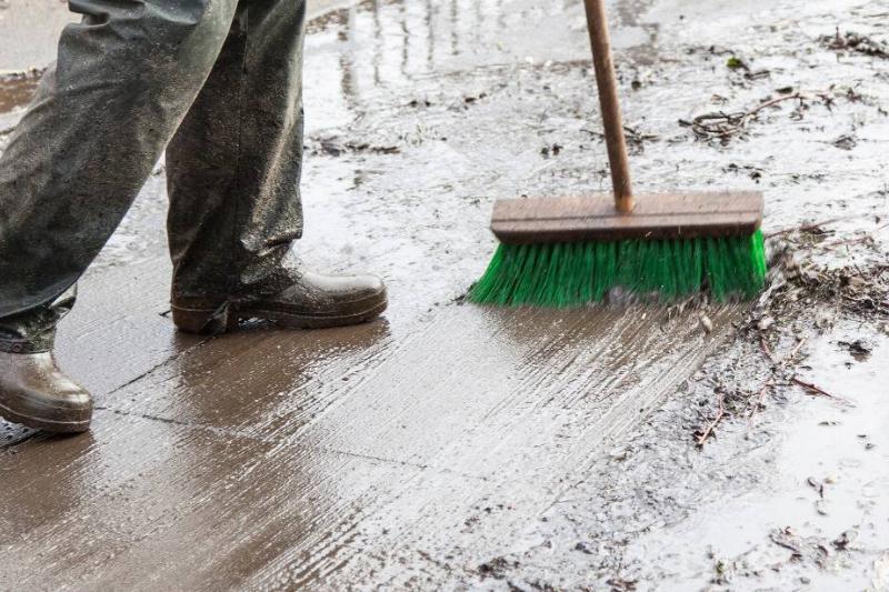Sweeping up oil stain on driveway. 