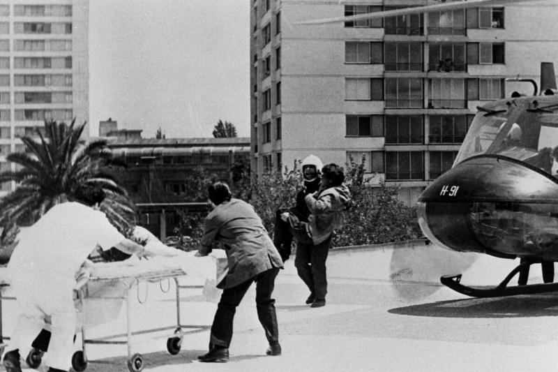 Helicopter crewmen carry survivor of the October 13th Uruguayan plane crash on a stretcher to the Santiago Central First Aid Station heliport.