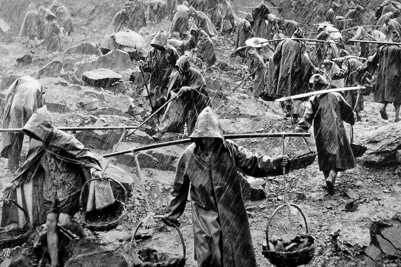 China: A team of workers labouring in a stone quarry in heavy rain during the 'Great Leap Forward' (1959 - 1961)
