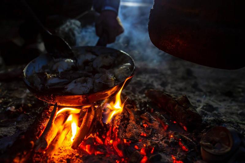 Cooking fish over an open fire.