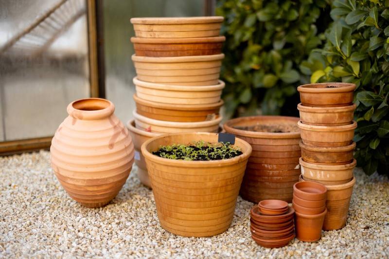 Empty clay pots ready for planting in garden outdoors.