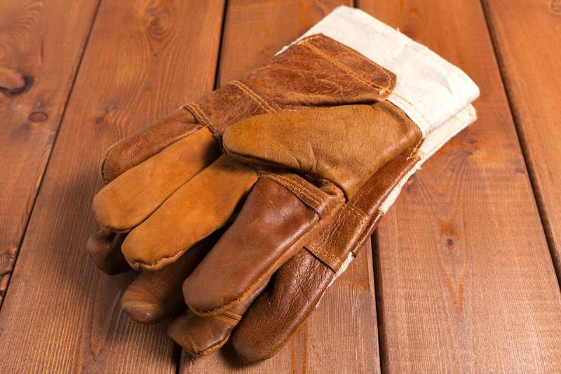 Leather gloves on wooden bench.
