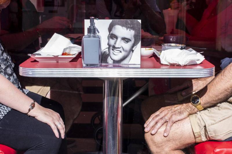 Couple sitting in diner with photo of Elvis on table in Whitby in England.