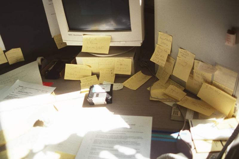 Desk, Computer And Wall Covered With Post-It Notes.