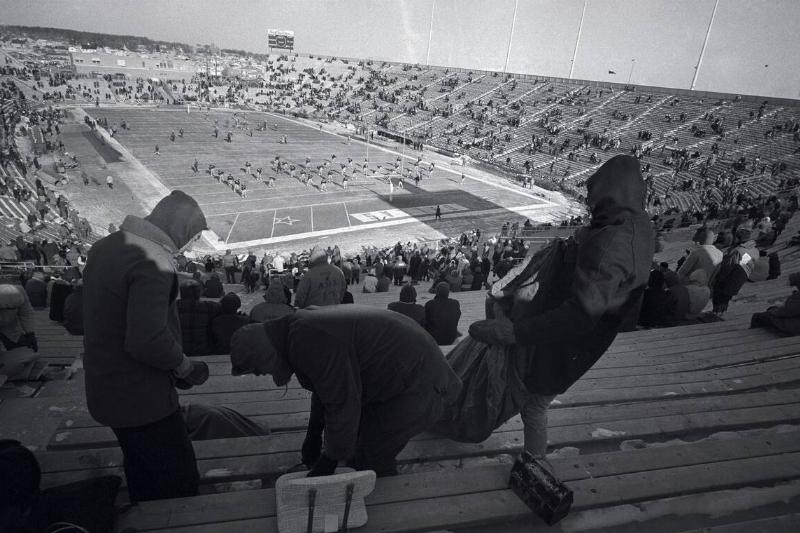 Fans Brushing Snow Off Seats at Stadium