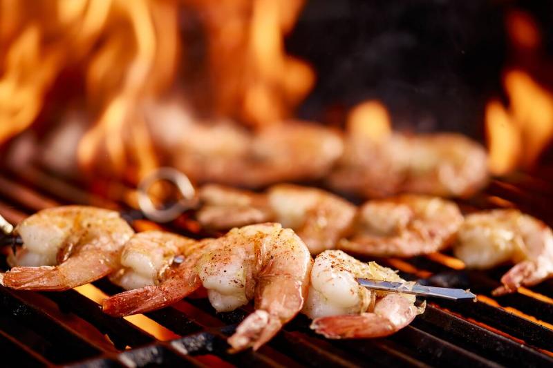 Grilling shrimp on skewer on grill.
