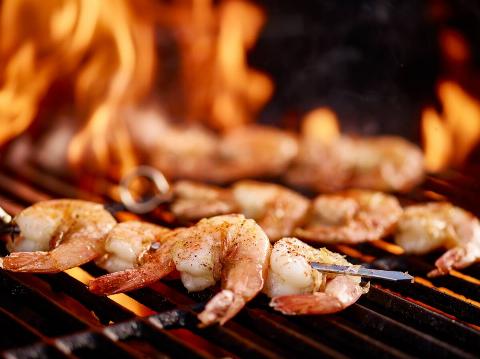 Grilling shrimp on skewer on grill.