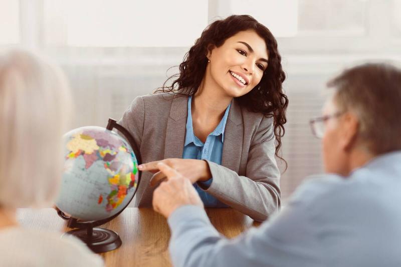 Travel agent showing a couple a globe.