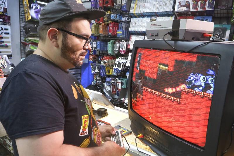 Long Island gaming store owner plays video game