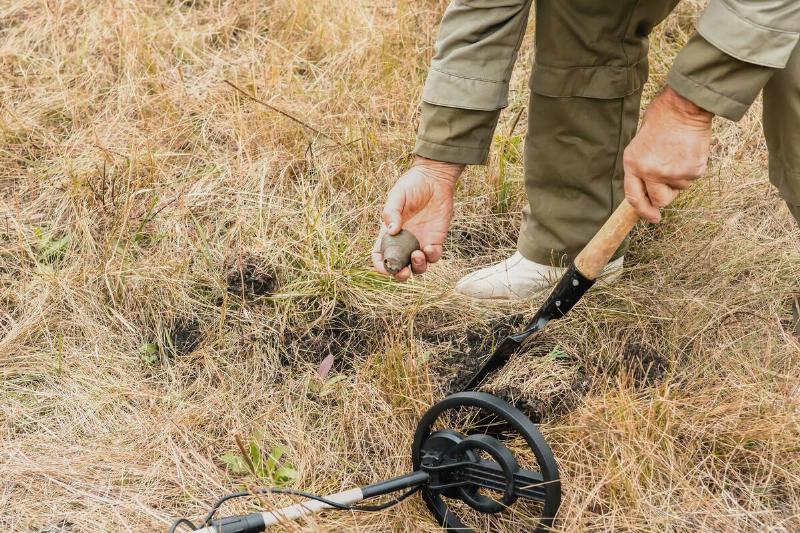 Man digging up finds from metal detector. 