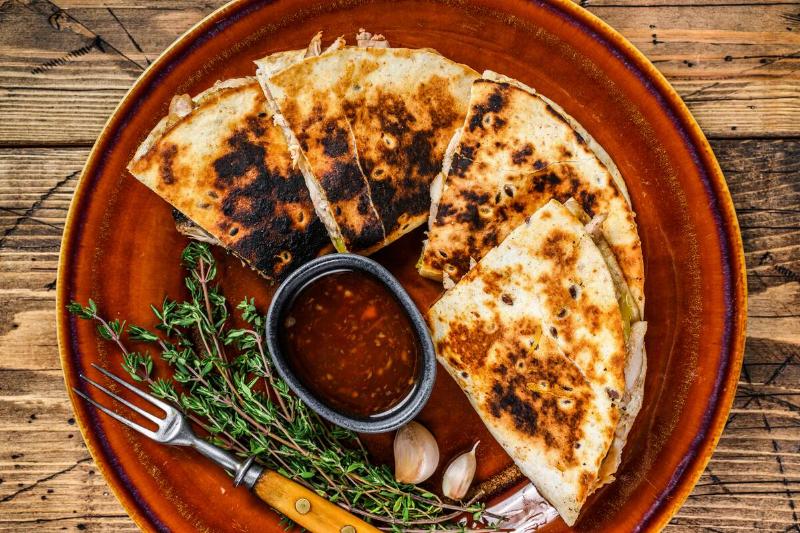 Quesadilla on a wooden cutting board. 