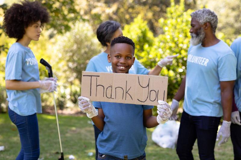 Boy holding thank you sign.