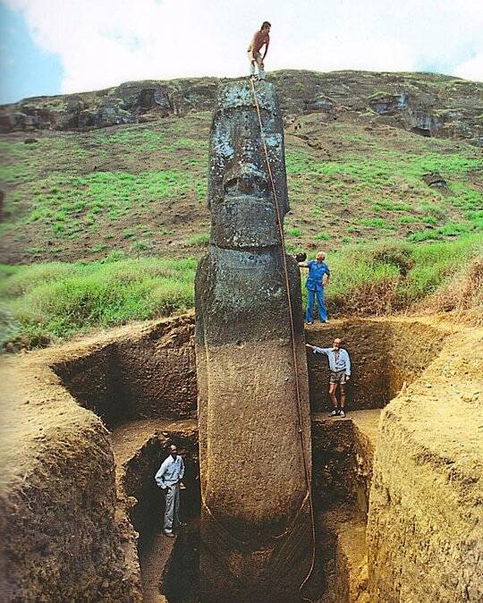 Man standing on Easter Island statue. 