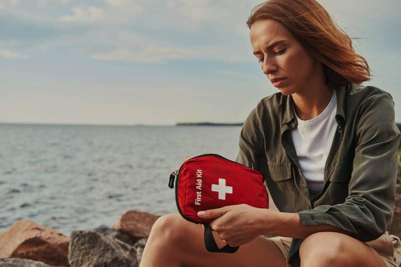 Woman holding first aid kit. 