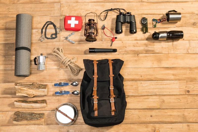Survival bag and items on wooden floor. 