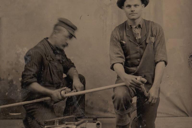 Two Plumbers With A Pipe