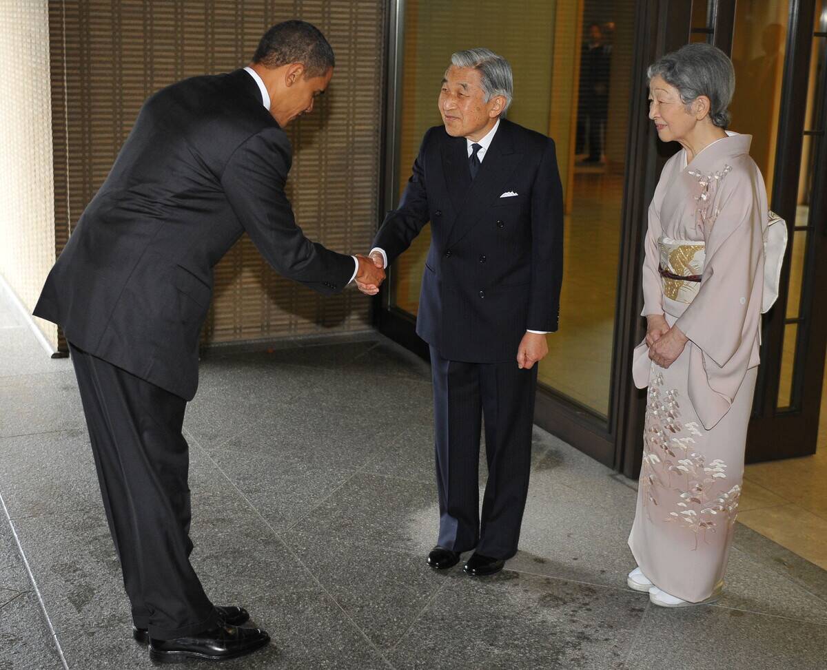US President Barack Obama (L) bows as he