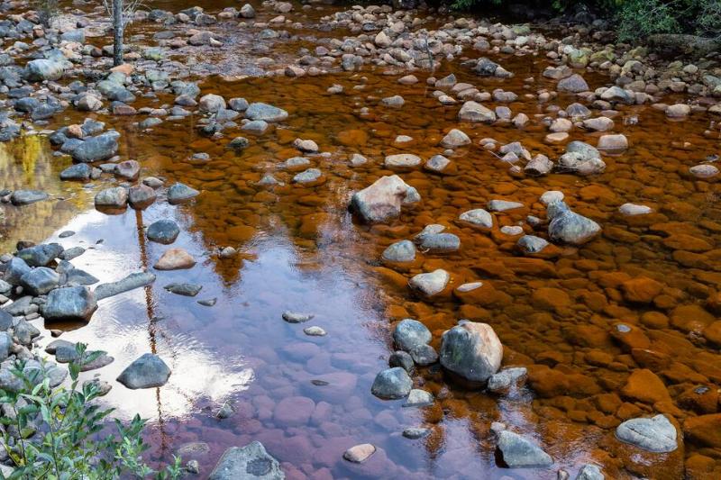 Water running down the river around rocks.