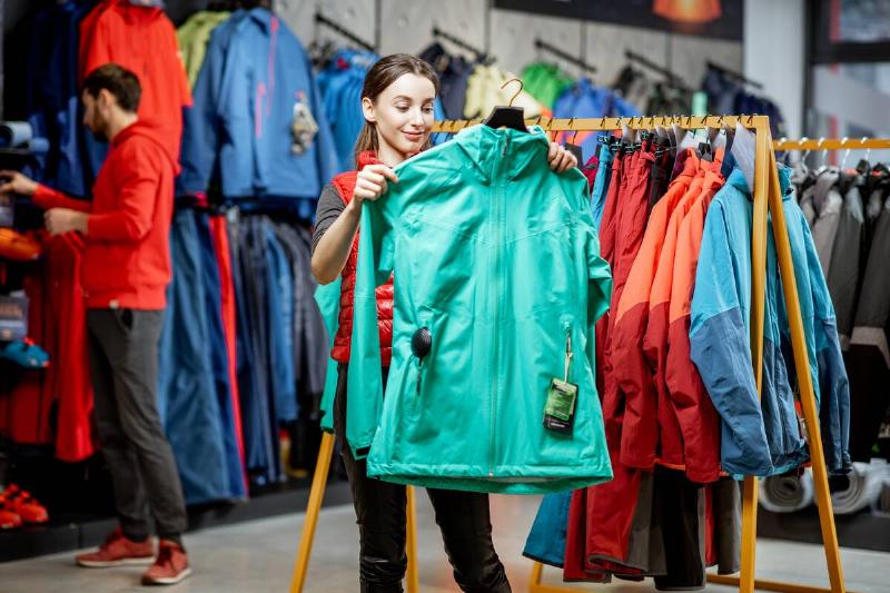 Woman shopping for waterproof jacket.