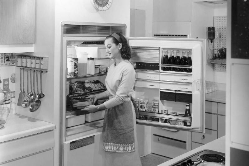Woman Placing Food Into Refrigerator