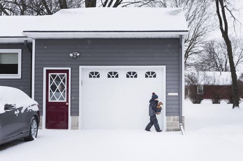 Boy with dog in front of garage door.