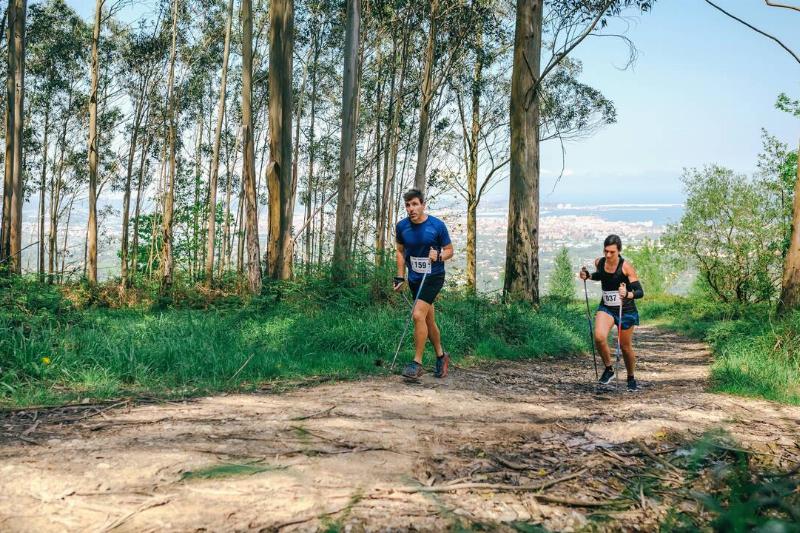 Young woman and man participating in a trail race through the forest