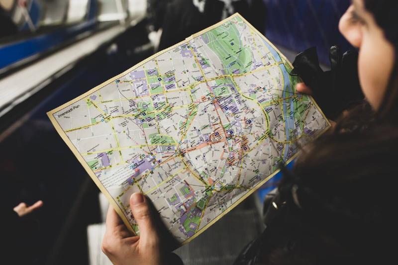 Young woman tourist studying the map of the city of Monaco of Bavaria.