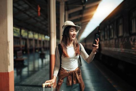 Woman on phone, waiting for train. 