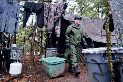 District Game Warden Aaron Cross exits Christopher Knight's camp.