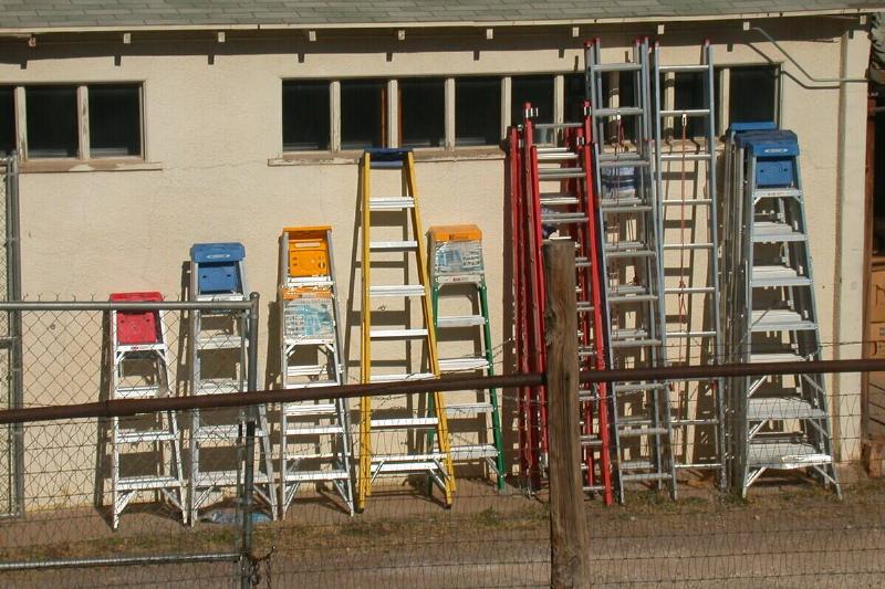 Different ladders against a wall. 
