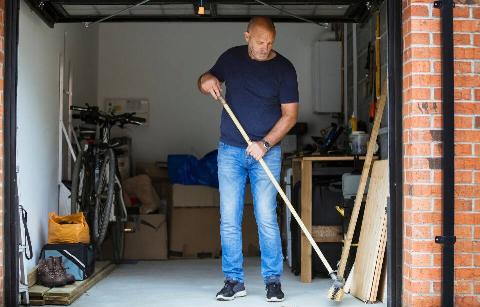 Man sweeping out garage.