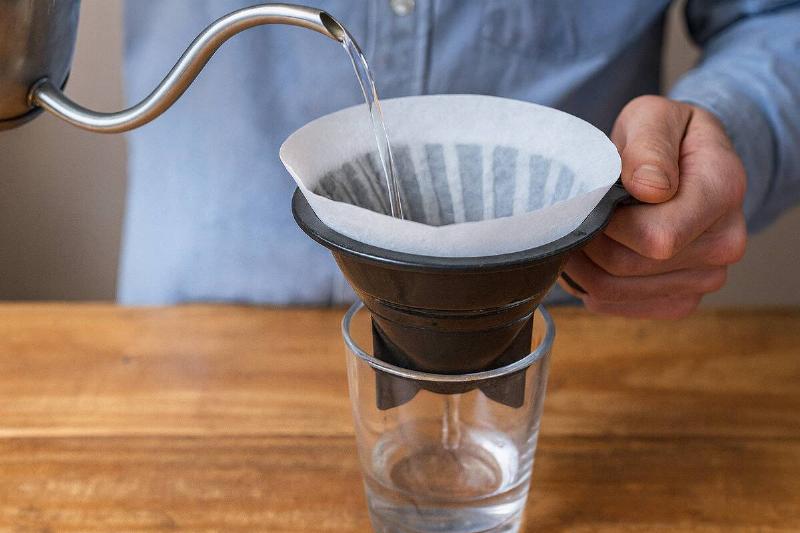Man using water filter to filter water. 
